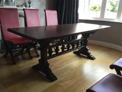 Vintage dark wood trestle dining table with 6 red leather backed chairs